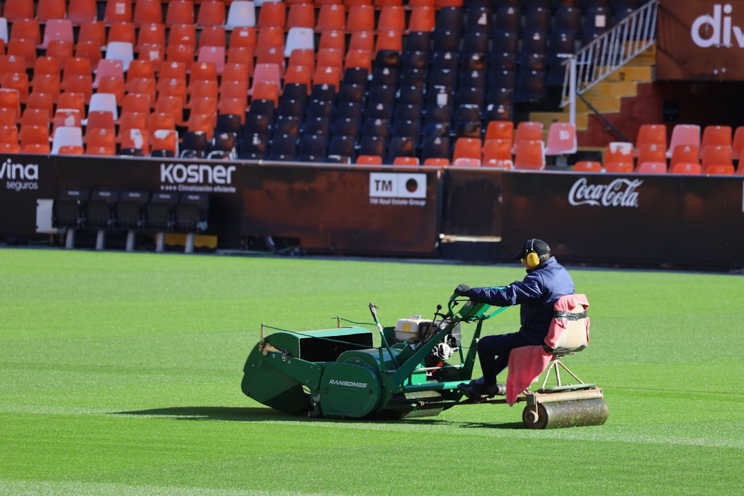 Mies ajaa ruohonleikkuria nurmikolla kauden aloitushuollon jälkeen